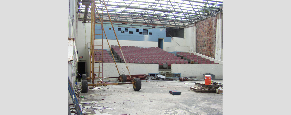 An empty theater with an unfinished roof undergoing renovation. 